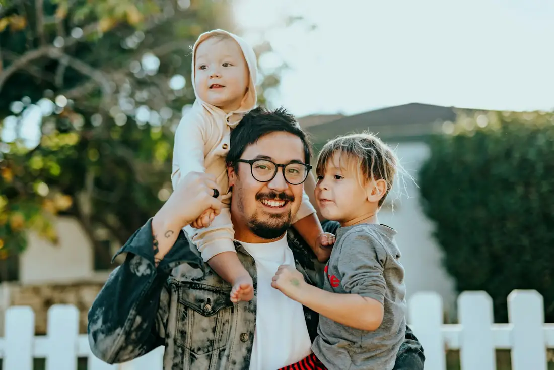 Pai brincando com os filhos no quintal de casa